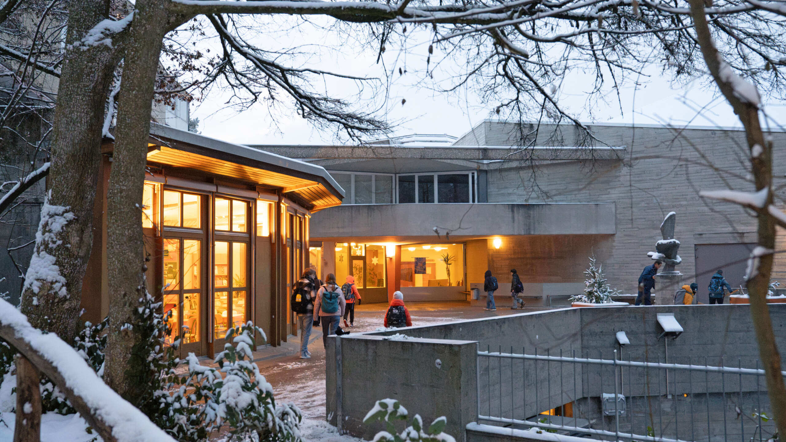 Winterliche Vorderansicht der Rudolf Steiner Schule Basel mit Eingangsbereich und Kindern die zur Schule gehen
