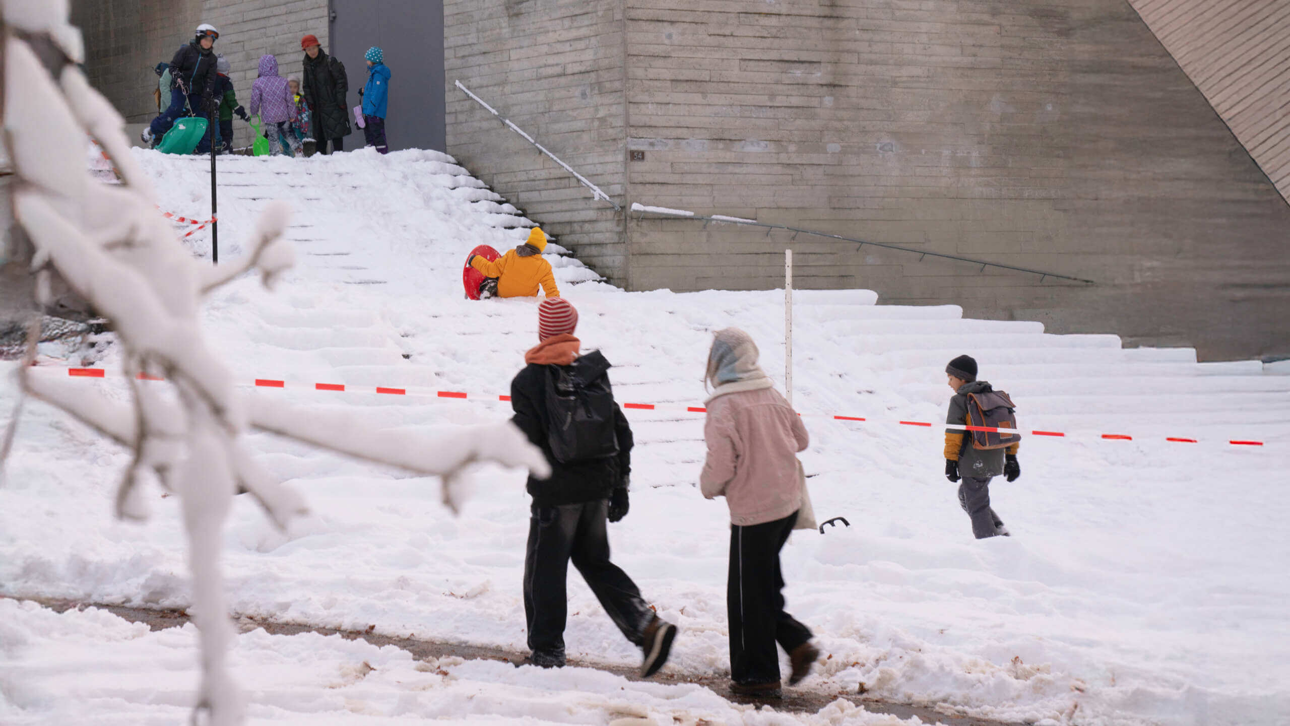 Winterliche Vorderansicht der Rudolf Steiner Schule Basel mit schneebedecktem Treppenaufgang und Kindern die zur Schule gehen